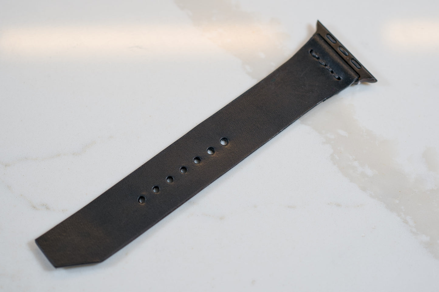 Black Apple Watch leather band made from Wickett & Craig Traditional Harness leather, offering a sleek and versatile accessory for any Apple Watch enthusiast. | Bracelet en cuir noir pour Apple Watch fabriqué à partir de cuir Wickett & Craig Traditional Harness, offrant un accessoire élégant et polyvalent pour tout amateur d'Apple Watch.
