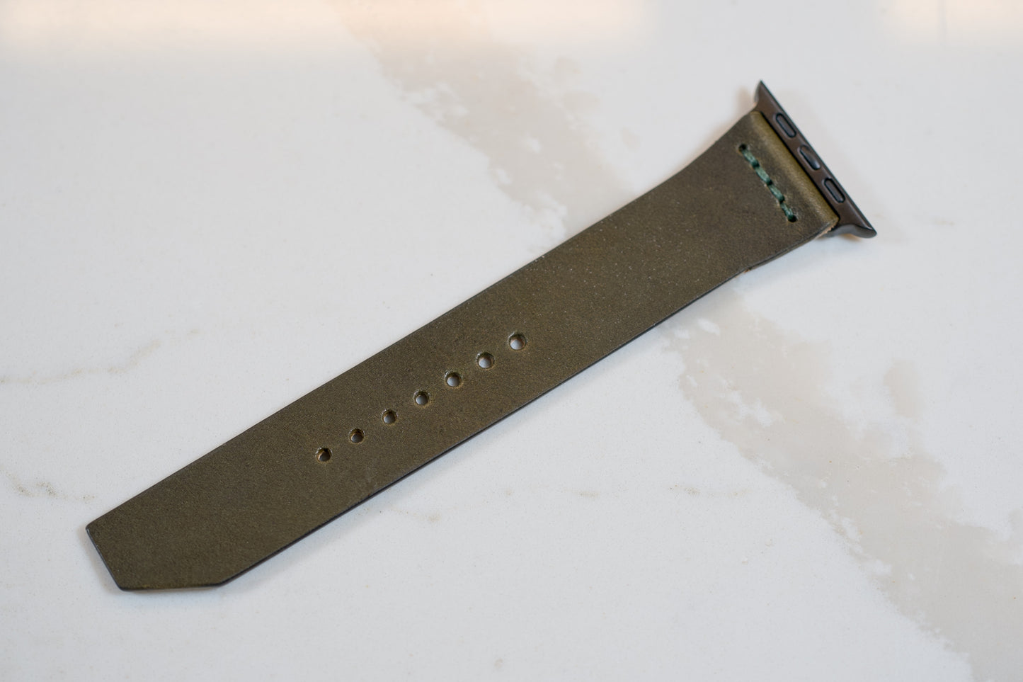Olive green Apple Watch leather band crafted from eco-friendly vegetable-tanned Wickett & Craig Traditional Harness leather, combining style and durability. | Bracelet en cuir vert olive pour Apple Watch fabriqué à partir de cuir Wickett & Craig Traditional Harness tanné végétal, alliant style et durabilité.